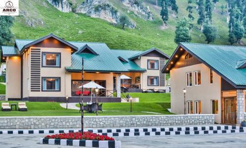 a house with a mountain in the background at Arco Hotels & Resorts sonamarg in Sonāmarg