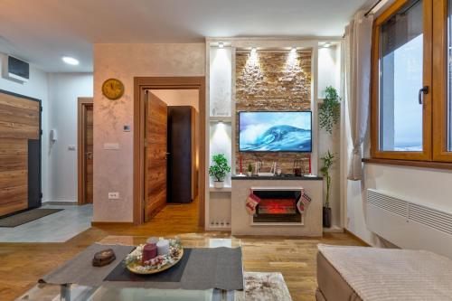 a living room with a fireplace and a tv at Apartman Kostić in Zlatibor