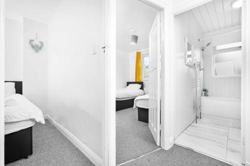 a room with two beds and a bathroom with a mirror at Home in Birmingham Cosy Stays in Birmingham