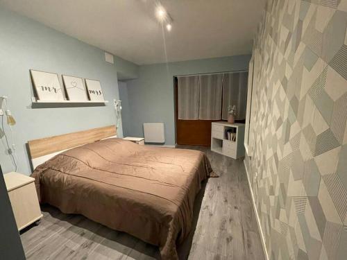 1 dormitorio con cama y pared en Au Coeur de la Cité Médiévale, en Montluçon