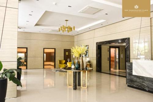 a lobby with a table with flowers on it at Mactan Newtown Beach Condo in Mactan