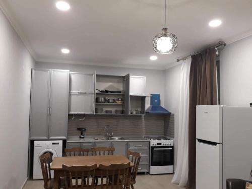 a kitchen with white appliances and a table and chairs at saxli tyis piras in Bakuriani