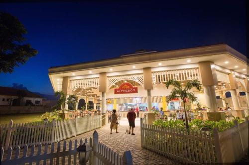 two people walking in front of a store at night at Mactan Newtown Beach Condo in Mactan