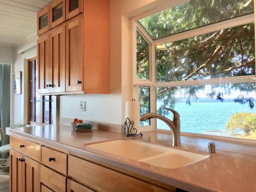 a kitchen with a sink and a large window at Breezy Point Hideout BY Betterstay in Saratoga Shores
