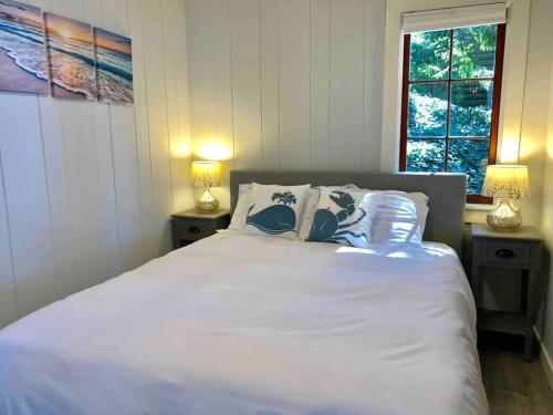 een slaapkamer met een wit bed en 2 nachtkastjes bij Breezy Point Hideout BY Betterstay in Saratoga Shores