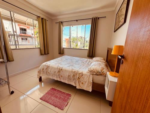 a bedroom with a bed and a window at Vila Madu in Bombinhas