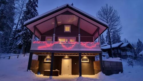 a house in the snow with christmas lights on it at Villa Magnolia 1 Himos in Jämsä