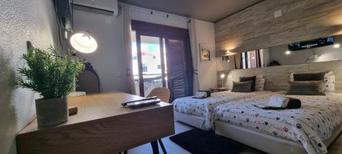 um quarto com uma cama e uma mesa com uma planta em MAIN AVENUE ALBUFEIRA, walk to beach, Old Town, shooping, top location em Albufeira