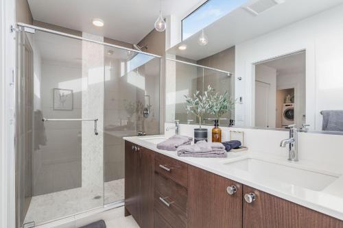 a bathroom with a glass shower and a sink at Centro house E BY Betterstay in Seattle