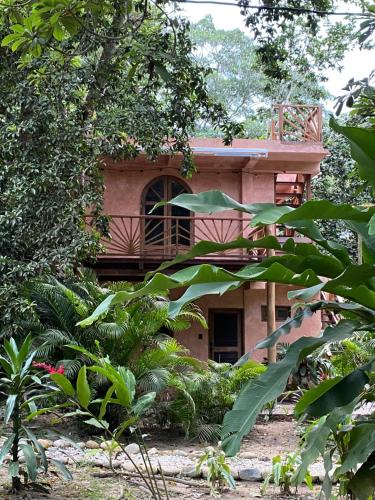 a building with a balcony in the middle of a garden at Salvia Madre Hotel Boutique in Guachaca