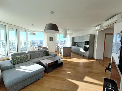 een woonkamer met een bank en een tafel bij Panorama Apartment 3 rooms 19th floor Great view Free parking in Bratislava