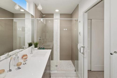 a white bathroom with two sinks and a shower at Centro house F BY Betterstay in Seattle