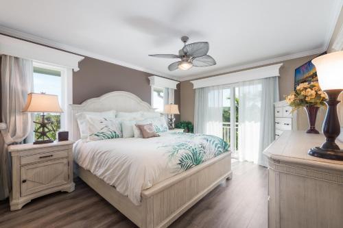 um quarto com uma cama e uma ventoinha de tecto em Palm Gables 112 em Holmes Beach