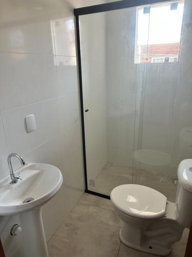 a bathroom with a shower and a toilet and a sink at apartamento Praia do Campeche, Jardim Eucaliptos in Florianópolis