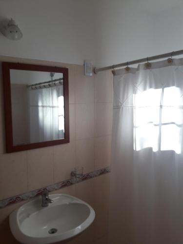 a bathroom with a sink and a mirror and a window at Mi lugar in Piriápolis