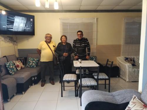 a group of three people standing in a waiting room at Qaleta Azul in Camaná