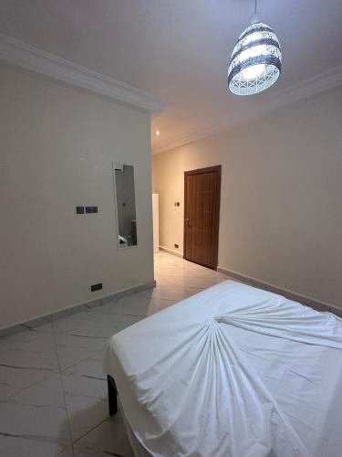 a white room with a bed and a light at Apartments Plaza Hotel in Kololi