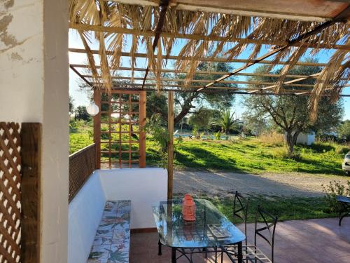 a patio with a glass table and chairs on a porch at casa entre mer et montagne in Arcos de la Frontera