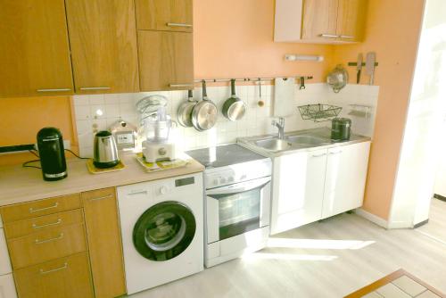 a kitchen with a washing machine and a sink at Détente et sport 2 - Chartreuse et Lacs - Chambre chez l'habitant in Saint-Béron