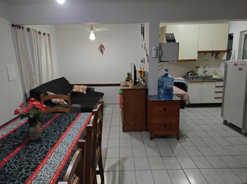 a living room with a couch and a kitchen at Sobrado para temporada 200m da praia Itapoá SC in Itapoa