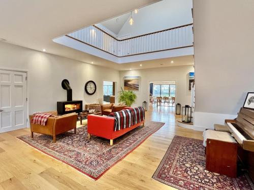 a living room with a red couch and a piano at The Shallows by inspirestays-com in North Hayling