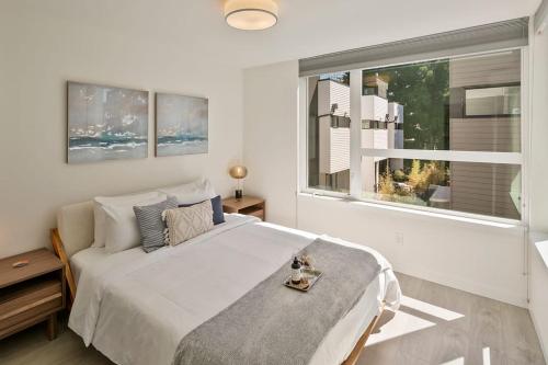 a white bedroom with a large bed and a window at Urban Abode 18 BY Betterstay in Seattle