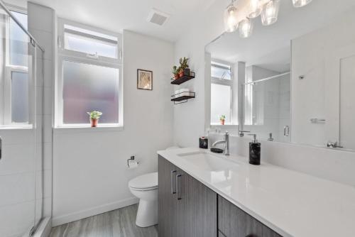 a white bathroom with a sink and a toilet at Urban Abode 22 BY Betterstay in Seattle