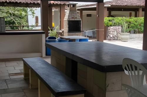 an outdoor kitchen with a large island with benches at Sítio com Piscina em Aldeia in Camaragibe