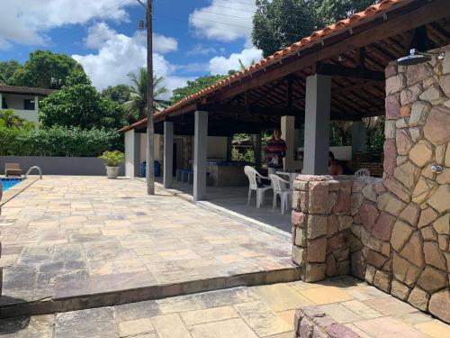 eine Terrasse eines Hauses mit einer Steinmauer in der Unterkunft Sítio com Piscina em Aldeia in Camaragibe