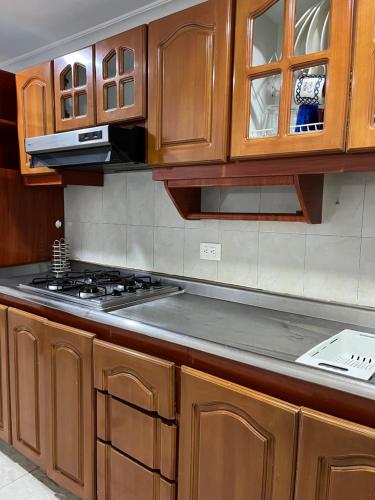 uma cozinha com armários de madeira e um forno com placa de fogão em Way Maker sede 2 em Bogotá