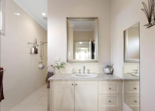uma casa de banho branca com um lavatório e um espelho em North Shore Hamptons em Cowes