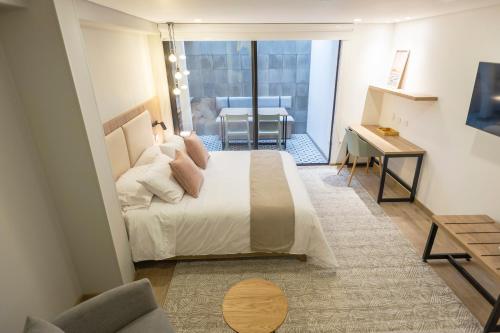 a bedroom with a large bed with a view of a balcony at Siete Balcones Hotel Coworking in Pasto