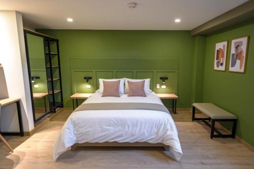a bedroom with a large bed with green walls at Siete Balcones Hotel Coworking in Pasto