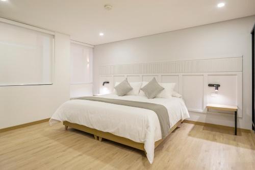 a bedroom with a large bed with white sheets and pillows at Siete Balcones Hotel Coworking in Pasto