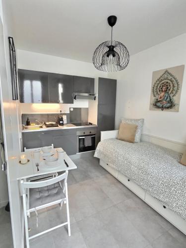 une chambre avec un lit et une table et une cuisine dans l'établissement Studio Cosy Vanves Paris Porte de Versailles, à Vanves