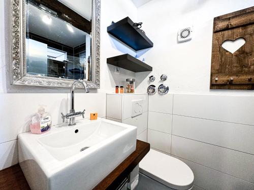 a bathroom with a white sink and a mirror at FEWO Yeti in Oberstaufen