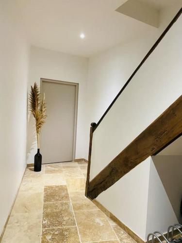 a room with a staircase and a vase with a plant at Magnifique appartement neuf 70m2 lumineux parking in Cahors