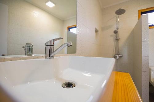 y baño con lavabo blanco y espejo. en Moderna Cabaña en Villarrica, en Villarrica