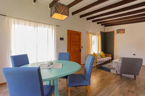 une salle à manger avec une table et des chaises bleues dans l'établissement Moderna Cabaña en Villarrica, à Villarrica