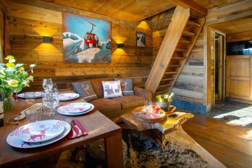 una sala de estar con sofá y mesa en una cabaña en Le Mazot de La Caillère - OVO Network en La Giettaz