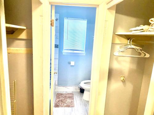 a small bathroom with a toilet and a window at Cozy place near FedEx Forum- free shuttle to downtown in Memphis