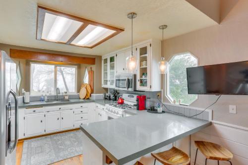 une grande cuisine avec des placards blancs et une grande fenêtre dans l'établissement Mid-Century Mod Cottage, Steps to Lake Gregory!, à Crestline