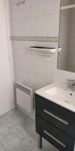 une salle de bain blanche avec un lavabo et un miroir dans l'établissement Maison de village au coeur de saint Cyprien village, à Saint-Cyprien