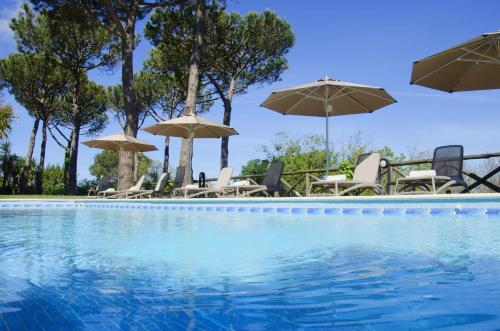 uma piscina com cadeiras e guarda-sóis em Elegant Sorrento Coast Villa with Pool and Tennis Court em Massa Lubrense