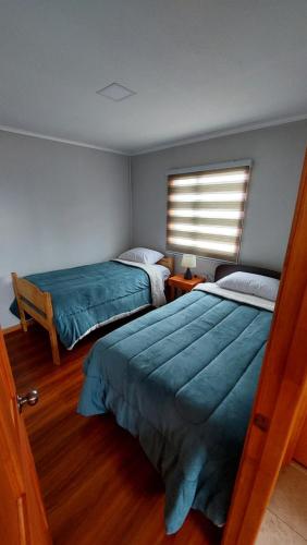 1 dormitorio con 2 camas y ventana en Antü Küyen Patagónica, en Puerto Natales