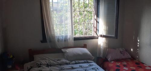 1 dormitorio con cama y ventana en 9 amigos en Villa Gesell