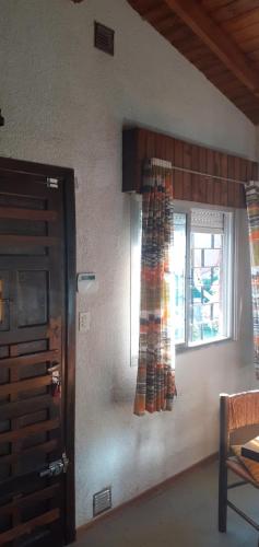 Habitación con puerta y ventana con cortinas. en 9 amigos en Villa Gesell