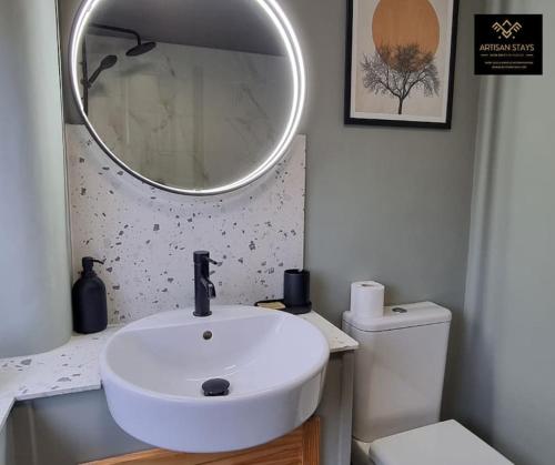 a bathroom with a white sink and a mirror at The Rose Garden of Basildon in the Heart of Basildon by Artisan Stays I Weekly or Monthly Stay Offer I Pvt Parking I Sleeps 6 in Basildon