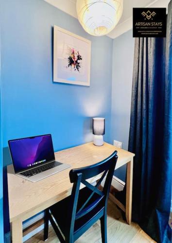 a desk with a laptop computer on top of it at The Rose Garden of Basildon in the Heart of Basildon by Artisan Stays I Weekly or Monthly Stay Offer I Pvt Parking I Sleeps 6 in Basildon