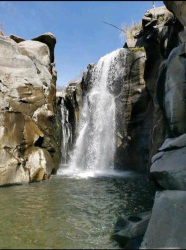 a waterfall in the middle of a rocky mountain at Serenity House Casa Huaxtla del Arenal in Huastla